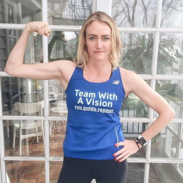 Heather B. Armstrong posing in a blue Team With A Vision shirt, flexing her right arm