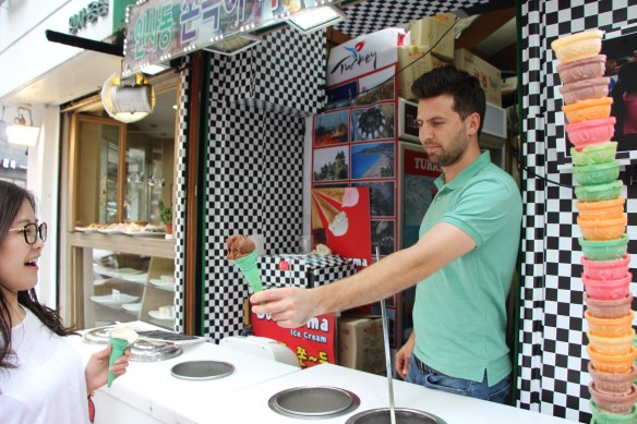 An ice cream vendor handing a customer a cone